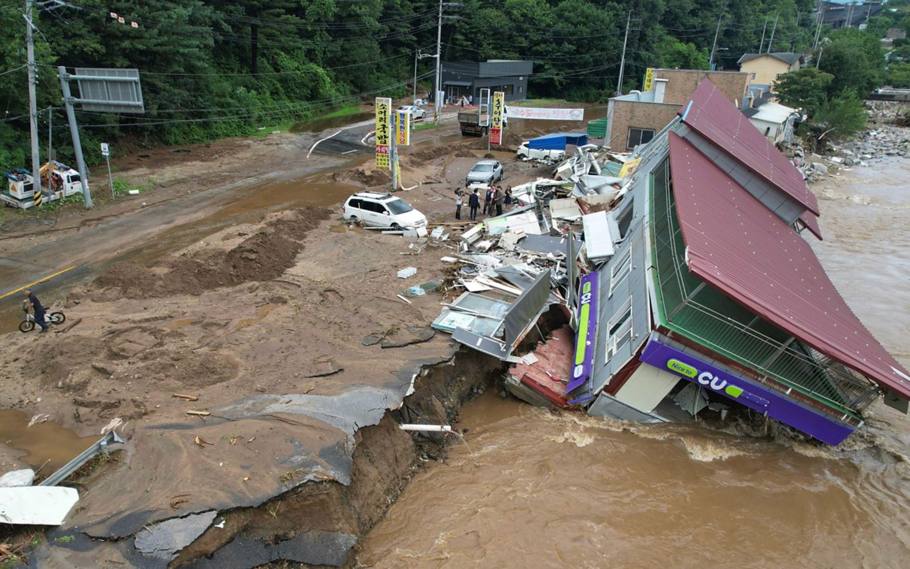 A picture of a flood which has swept away cars and houses