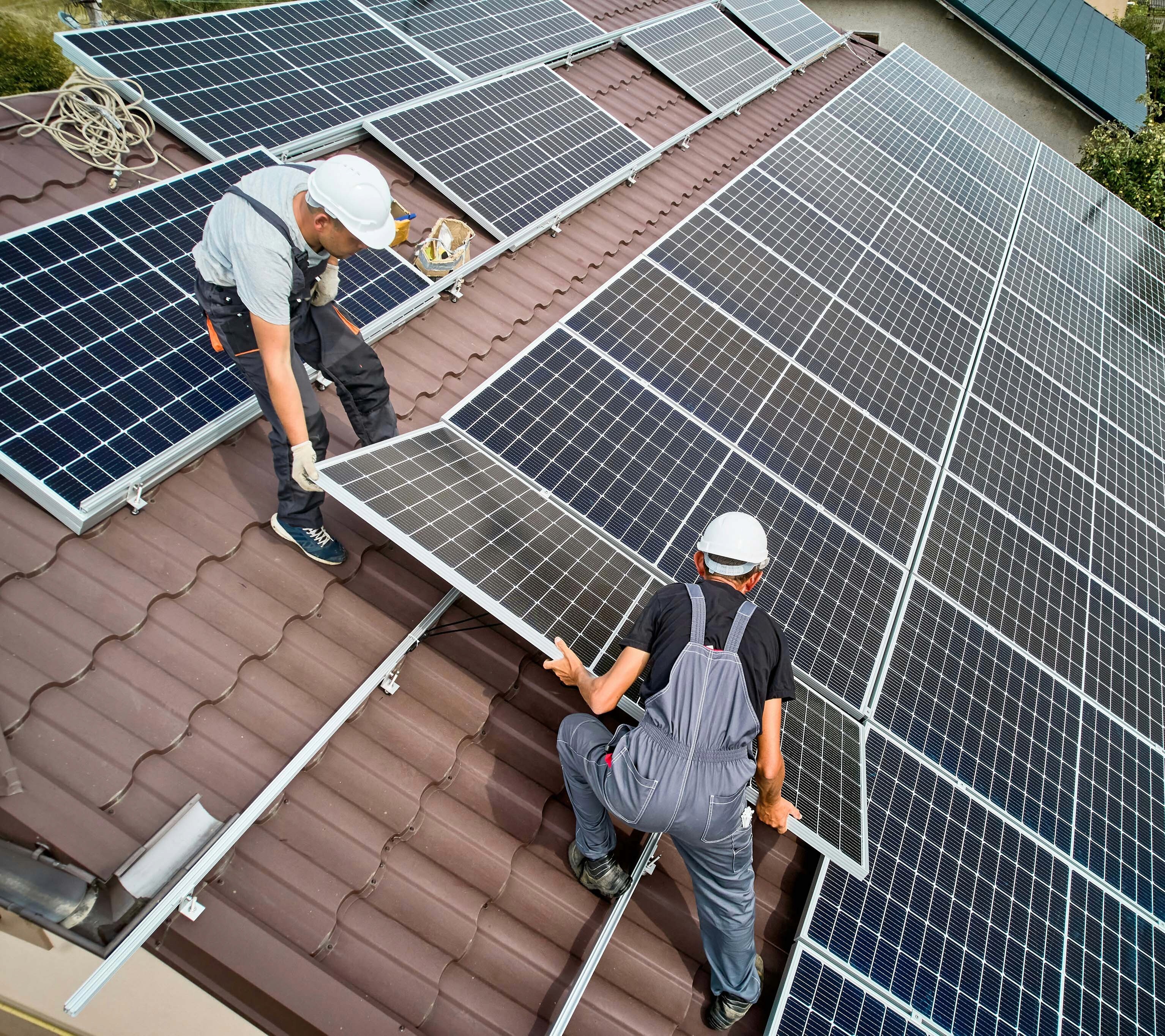 A picture of two men installing solar panels